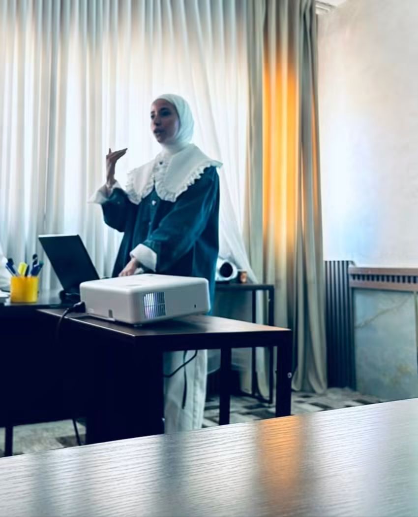 A facilitator presenting beside a projector at a regional screening